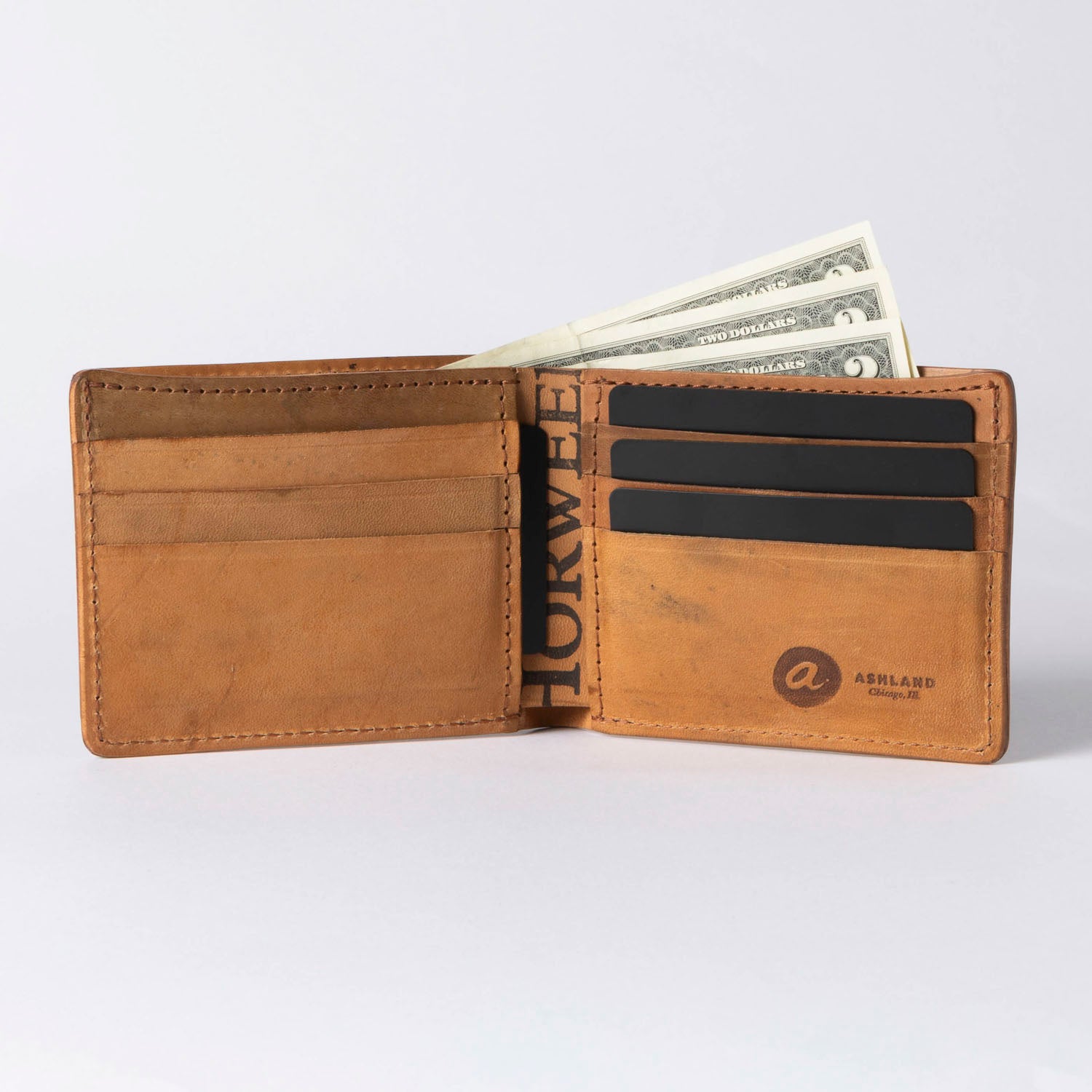 Brown leather wallet with money and cards on a white background