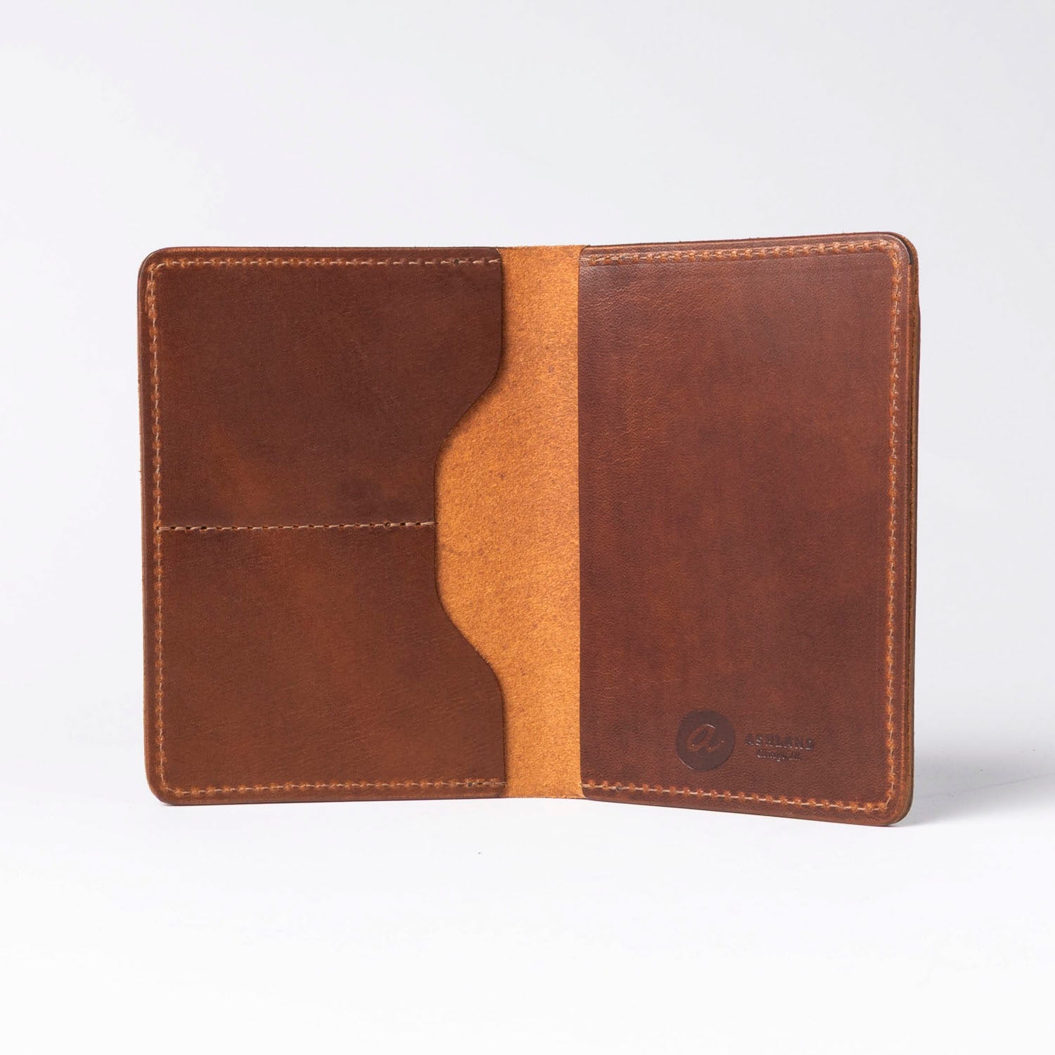 Brown leather passport holder with a visible brand logo on a white background