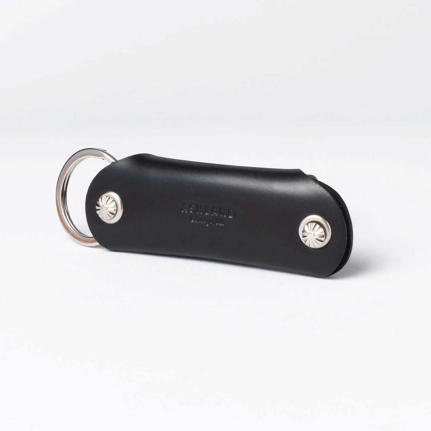 Black leather keychain with silver accents on a white background