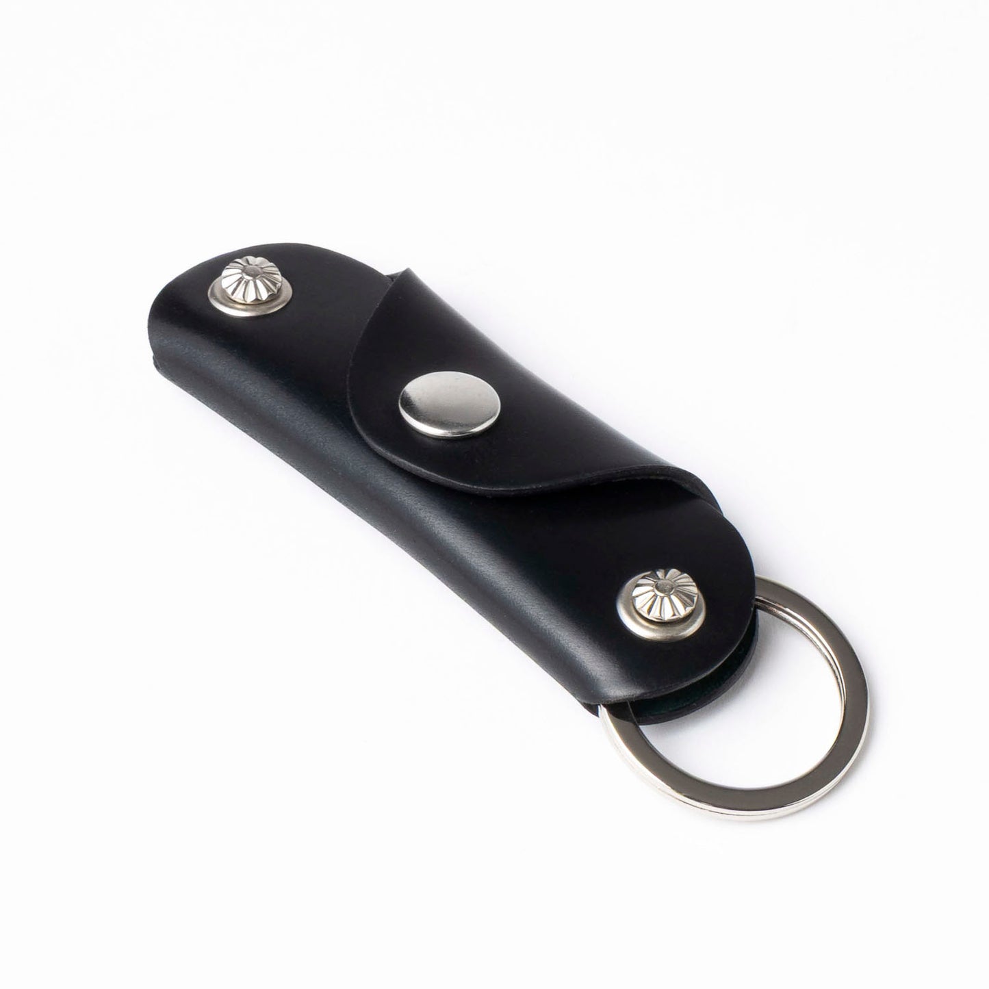 Black leather key fob with silver accents on a white background