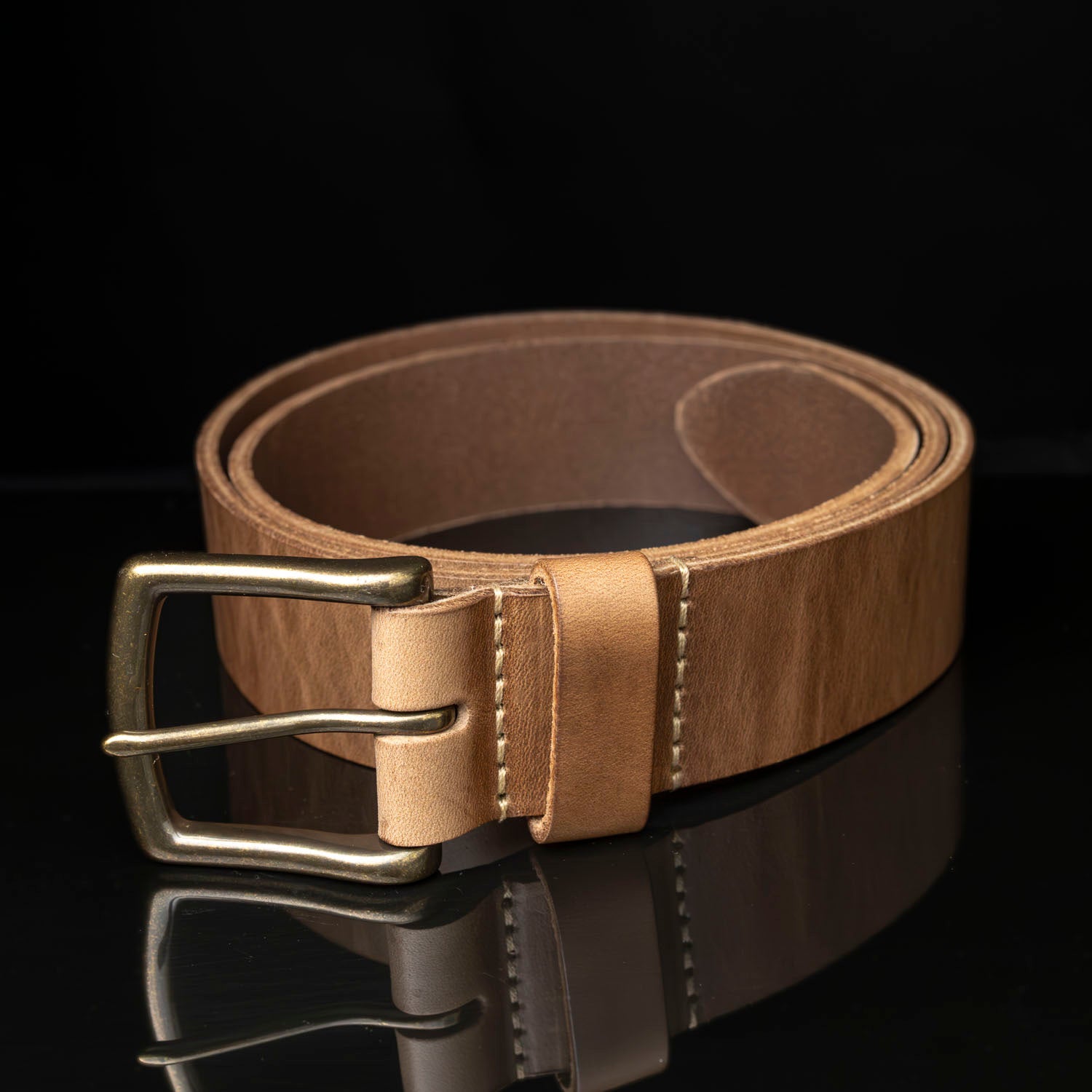 Ashland chromexcel belt coiled in a circle on black background