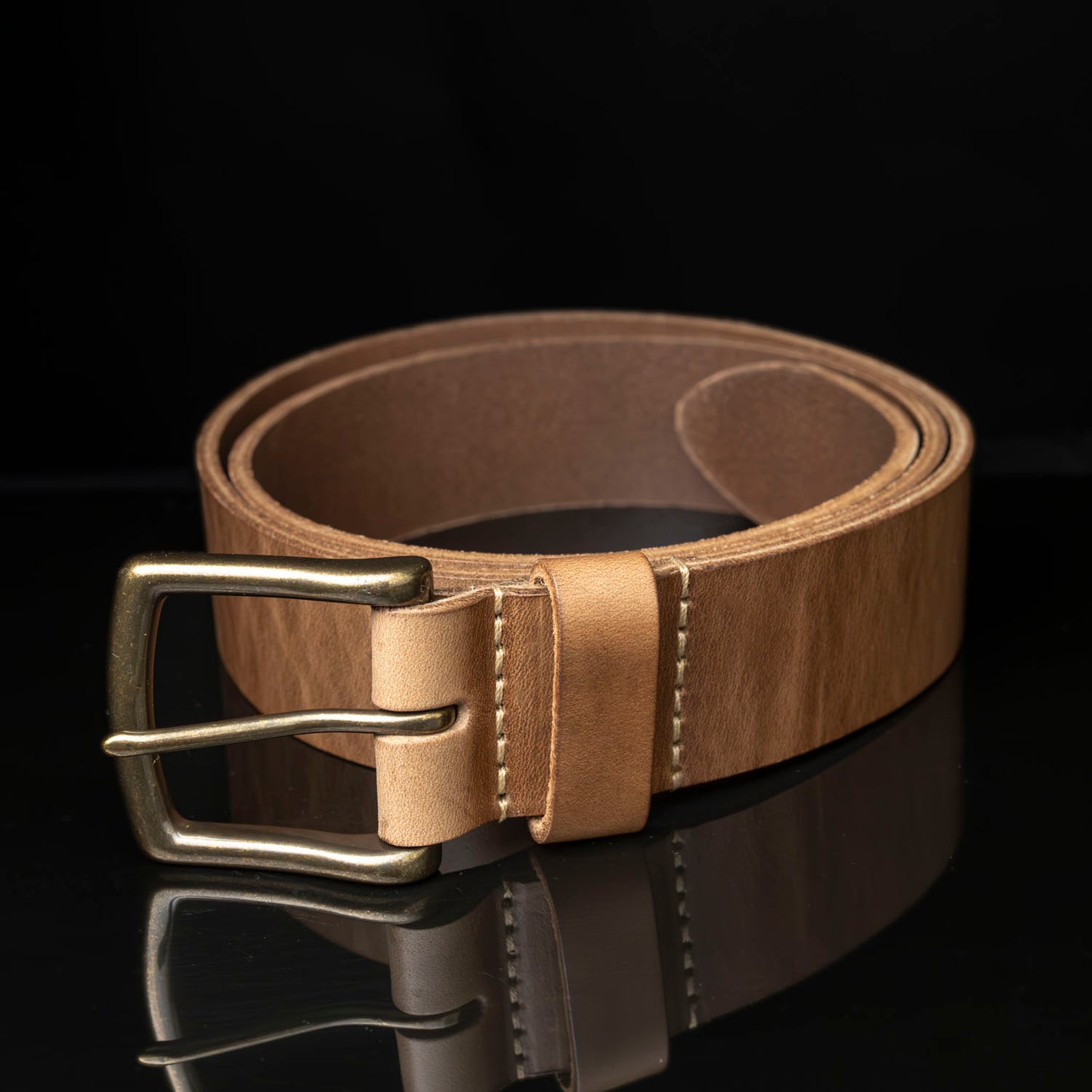 Ashland chromexcel belt coiled in a circle on black background