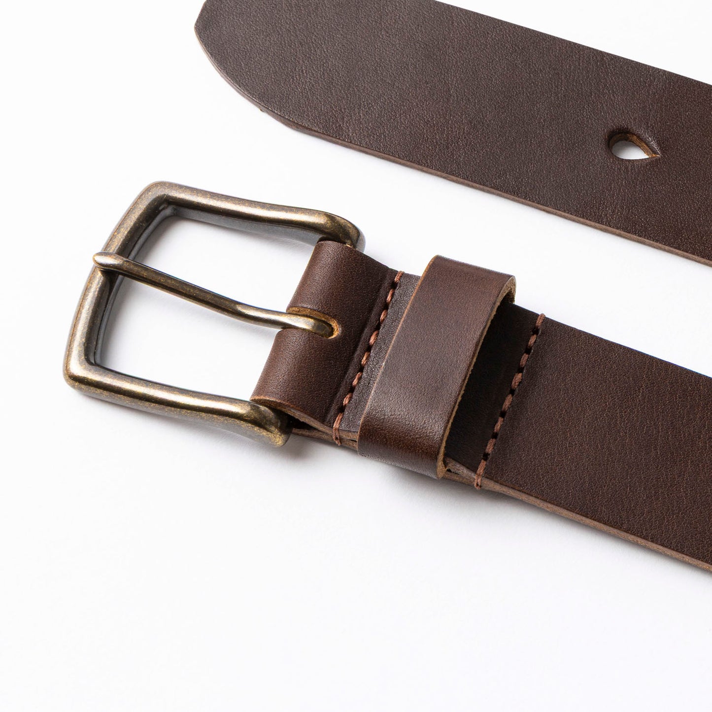 Brown leather belt with brass buckle on a white background