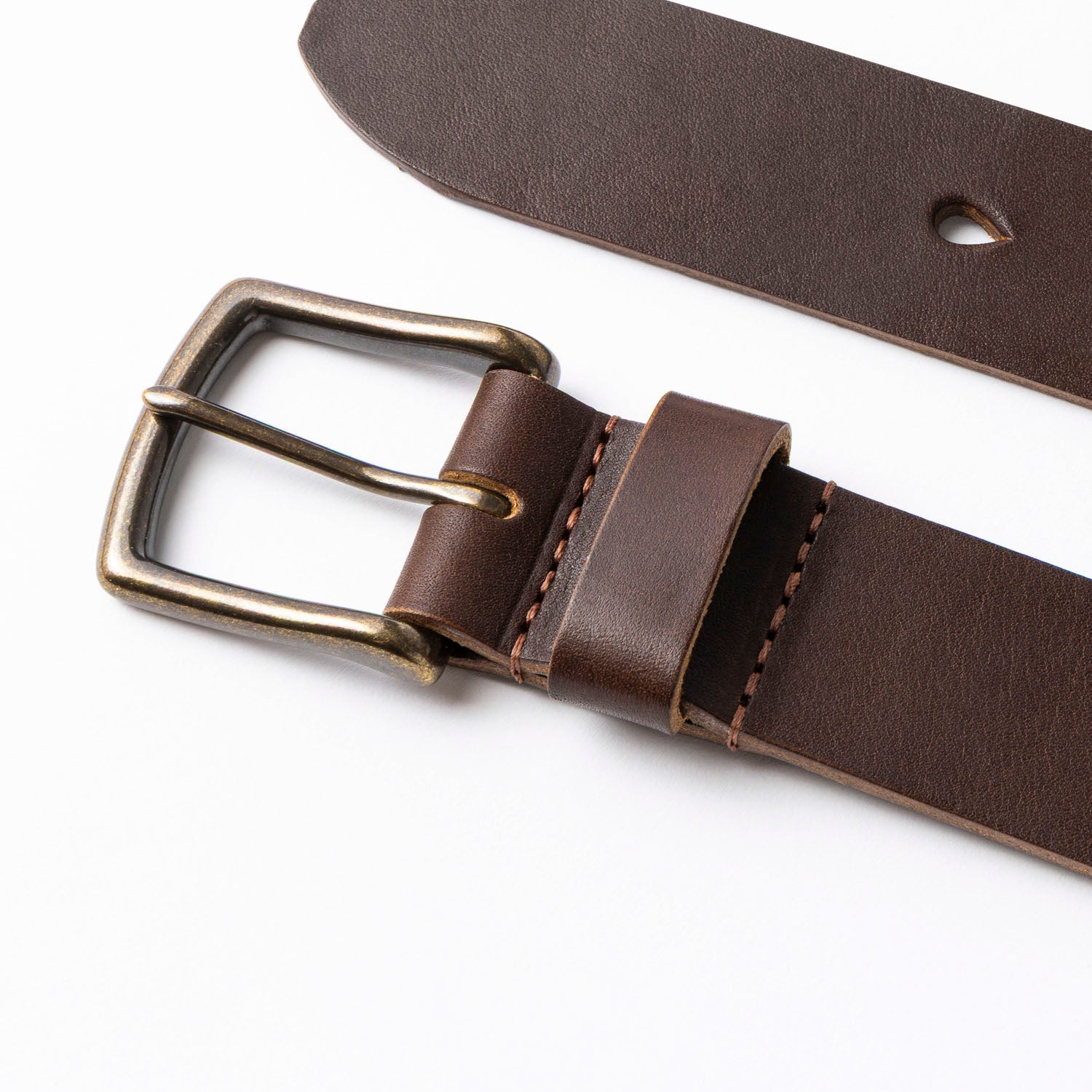 Brown leather belt with brass buckle on a white background