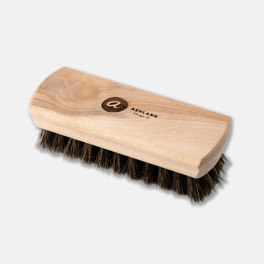 Wooden brush with bristles on a light gray background
