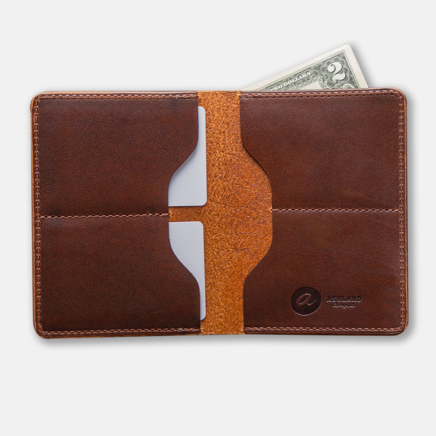 A large brown leather bifold wallet with card slots and a paper bill partially visible
