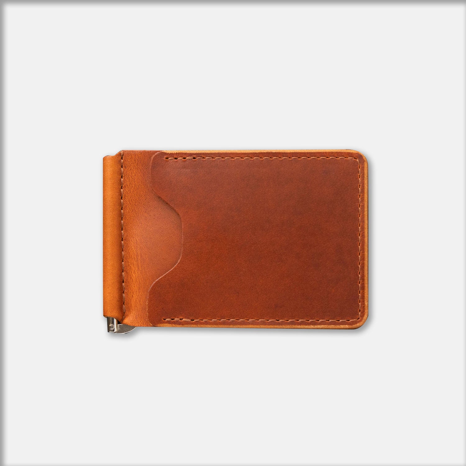 A brown leather money clip with a visible brass fastener
