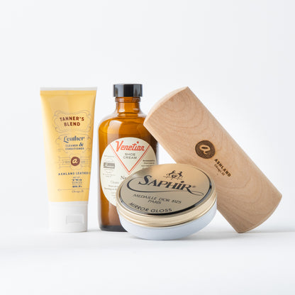 Collection of leather care products including a tube, bottle, and jar on a white background