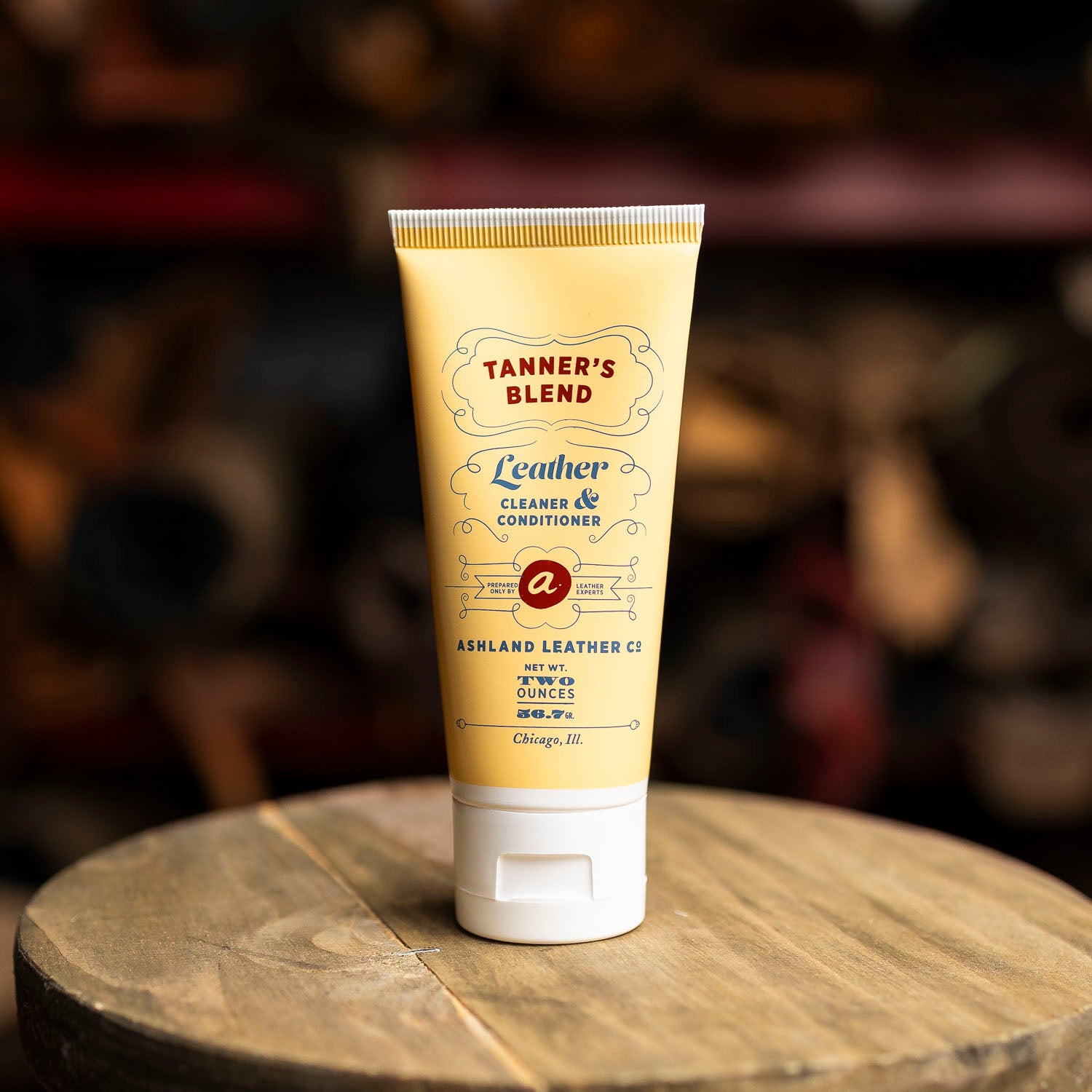 Tube of Tanner's Blend leather cleaner on a wooden surface with a blurred background